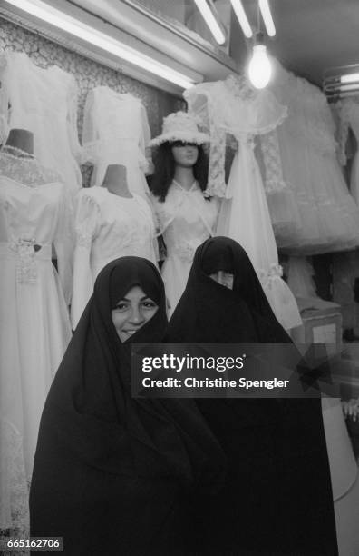 Two women in long chadors visit a bridal shop in Tehran.