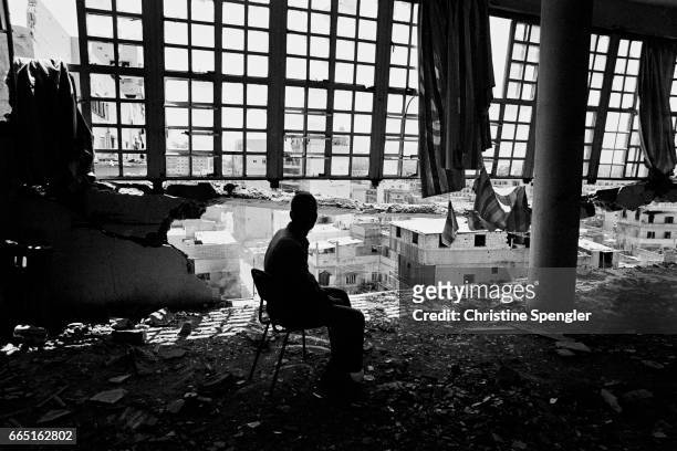 Man sits in a destroyed mental hospital in Sabra, a Palestinian refugee camp in Beirut, Lebanon. In the 1980s, Palestinian refugee camps came under...