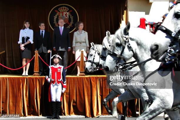 French President Nicolas Sarkozy, his wife Carla Bruni-Sarkozy, Spanish King Juan Carlos I, and Queen Sofia of Spain review the honor guard during a...