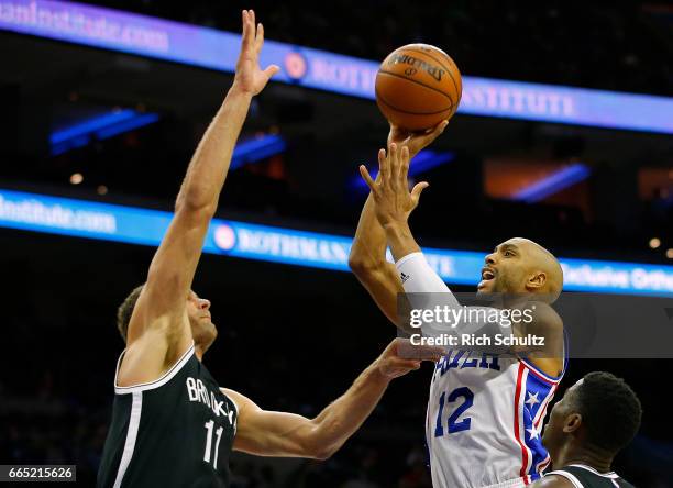 Gerald Henderson of the Philadelphia 76ers attempts a shot as Brook Lopez of the Brooklyn Nets defends in the second half during an NBA game at Wells...