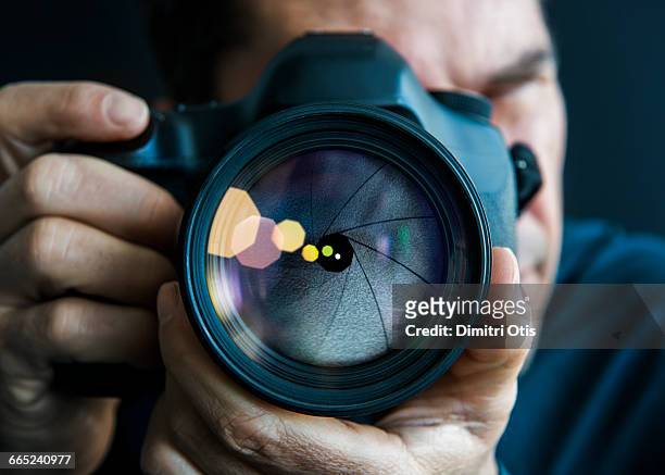 man holding camer, close-up of lens - photographer stock-fotos und bilder