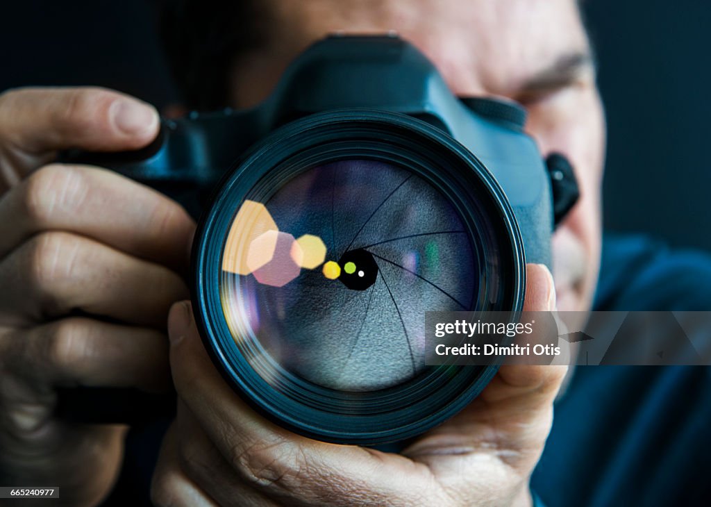 Man holding camer, close-up of lens