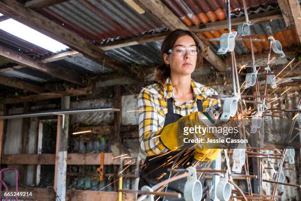 woman using grinder in workshop - new zealand small business stock pictures, royalty-free photos & images