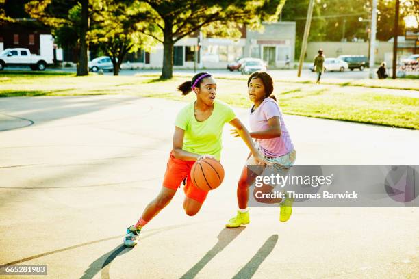 basketball player dribbling ball past defender - teenage girl basketball photos et images de collection