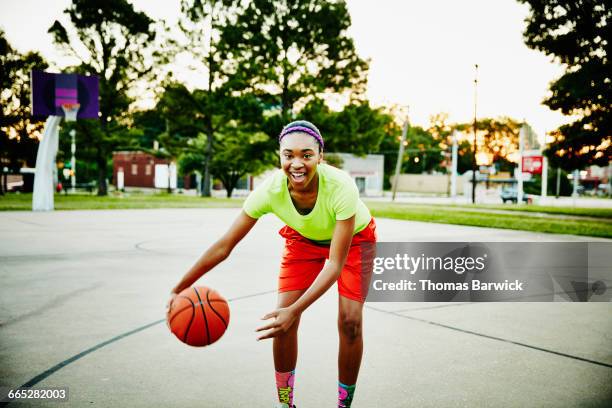 basketball player dribbling ball on outdoor court - dribbling sports imagens e fotografias de stock