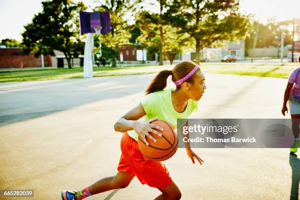 basketball player dribbling ball past defender - teenage girl basketball stock pictures, royalty-free photos & images