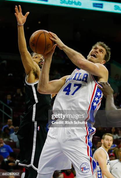 Tiago Splitter of the Philadelphia 76ers attempts a shot as Spencer Dinwiddie of the Brooklyn Nets defends in the second half during an NBA game at...