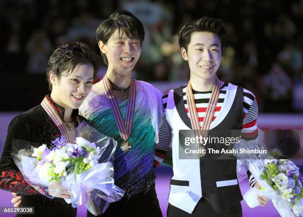 Silver medalist Shoma Uno and gold medalist Yuzuru Hanyu of Japan and bronze medalist Jin Boyang of China pose for photographs at the medal ceremony...