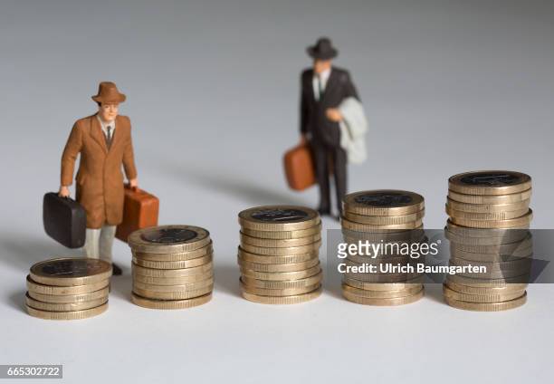 The managers, their salaries and other remunerations. The symbol photo shows several, differently high stacks of one euro coins and two miniature...