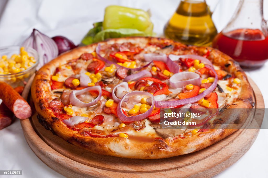 Pizza on a white background with ingredients around