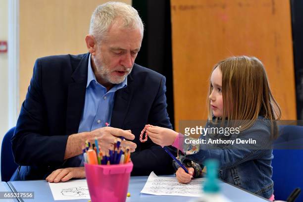 Leader of the Labour Party Jeremy Corbyn MP is given a loom band by Zofia Bylinski-Gelded during a visit to a children's holiday club in Leyand where...