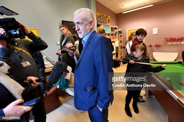 Leader of the Labour Party Jeremy Corbyn MP speaks to media as children play pool during a visit to a children's holiday club in Leyand where he made...