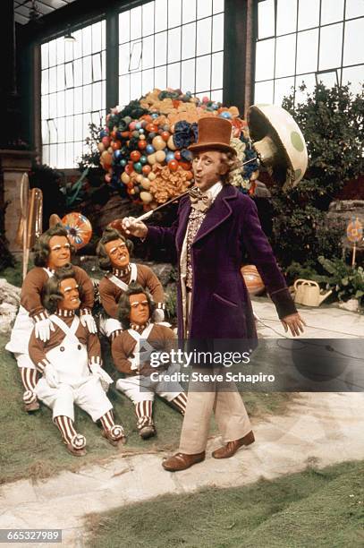 Gene Wilder as Willy Wonka walks past a group of Oompa Loompas on the set of the movie Willy Wonka & the Chocolate Factory, 1971.