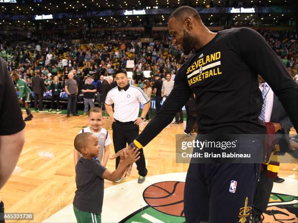 Jaiden son of Isaiah Thomas of the Boston Celtics high fives with LeBron James of the Cleveland Cavaliers on April 5, 2017 at the TD Garden in...