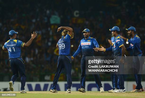 Sri Lankan cricketer Lasith Malinga celebrates with his teammates after taking a hat trick wicket to dismiss Bangladesh cricketer Mehedi Hasan during...
