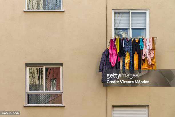 windows and hanging clothes - vestimenta stock-fotos und bilder