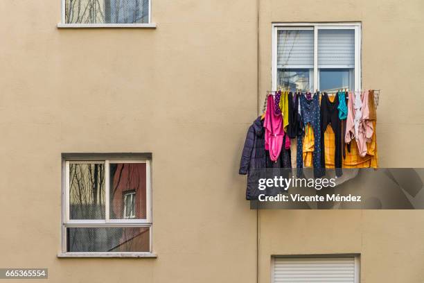 windows and hanging clothes - paisaje urbano stockfoto's en -beelden