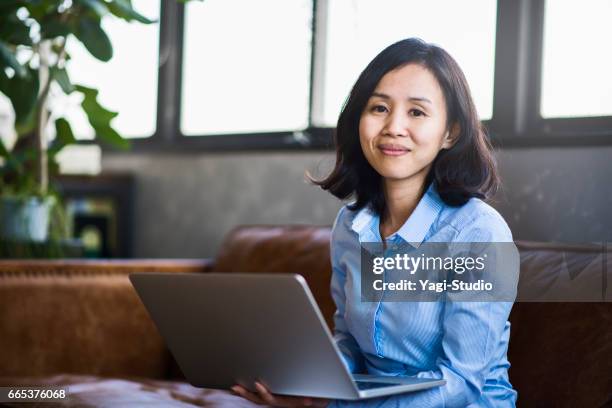 mid volwassen vrouwelijke ontwerper werken in een gedeelde kantoor. - medische artikelen stockfoto's en -beelden