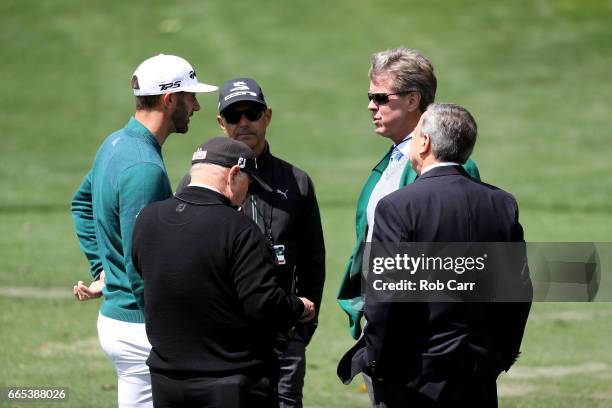 Dustin Johnson of the United States talks to Augusta National member Fred Ridley on the practice range prior to announcing his withdrawl during the...