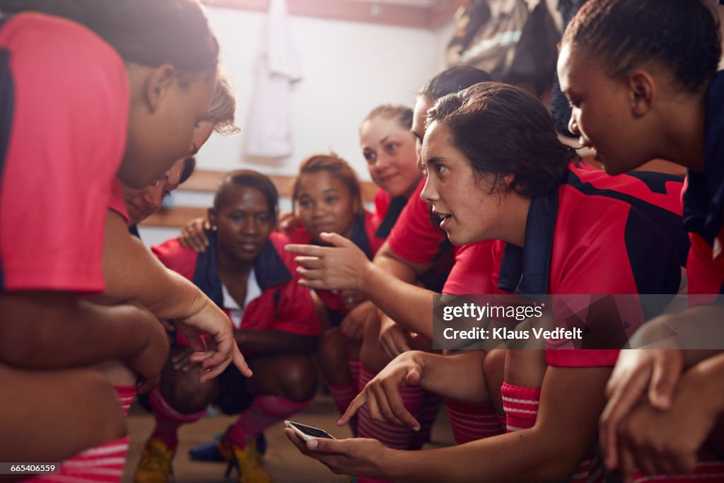 Womens rugby players looking at phone before game