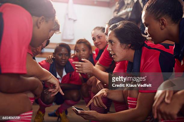 womens rugby players looking at phone before game - rugby sport stock-fotos und bilder