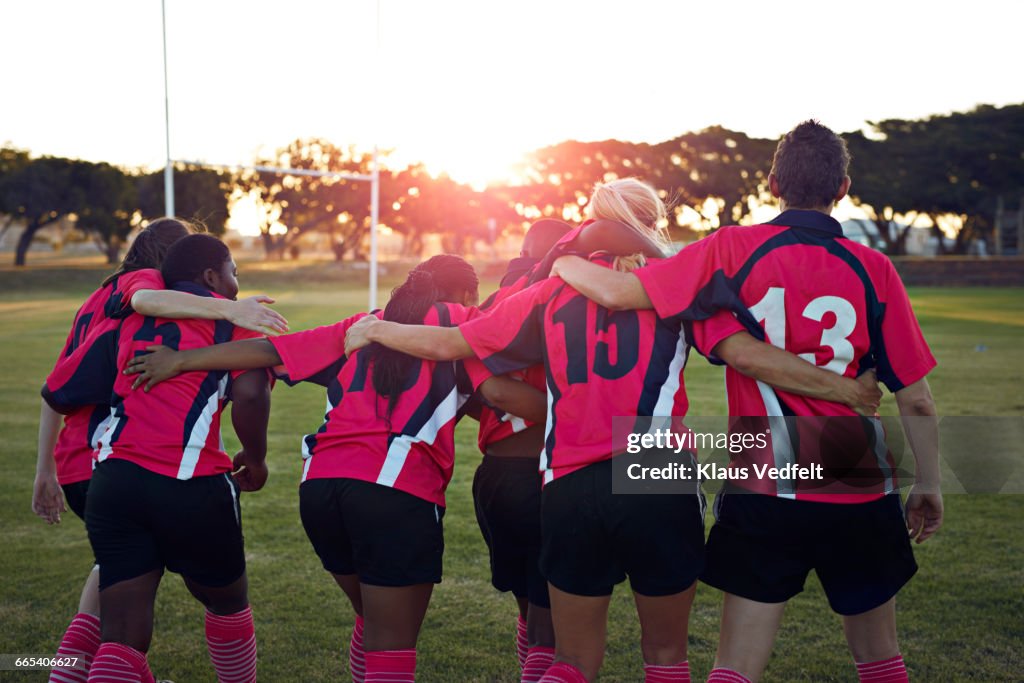 Womens rugby team walking together towards sunset
