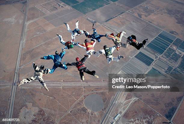 View of a group of skydivers freefalling in formation before activating their parachutes in the skies above the city of Lake Elsinore in California,...