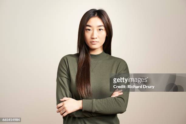 portrait of young woman with arms folded - women serious face photos et images de collection