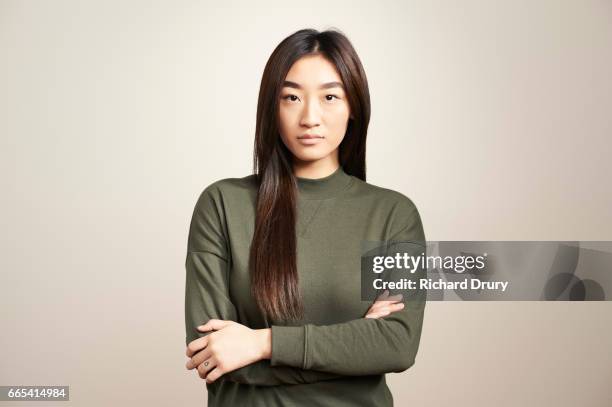 portrait of young woman with arms folded - portrait grey background confidence foto e immagini stock