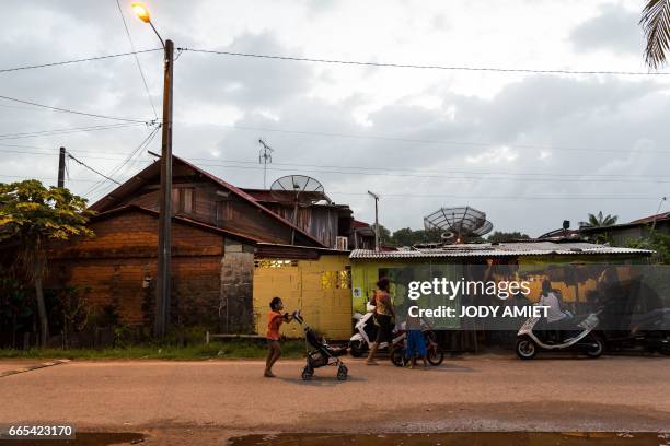 People go about with their daily life on March 31, 2017 in the district Matine-Leblond of Cayenne, French Guiana. - Air France canceled its scheduled...