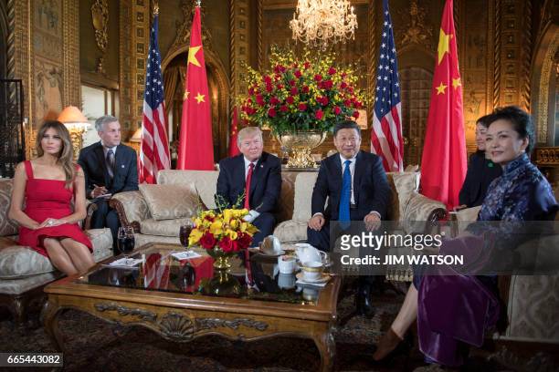 First Lady Melania Trump and US President Donald Trump pose with Chinese President Xi Jinping and his wife Peng Liyuan upon their arrival to the...