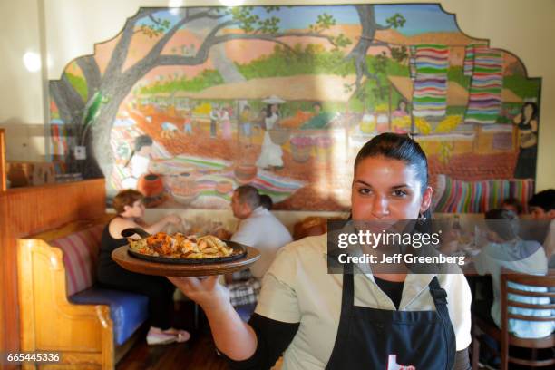 Waitress serving food at Casita Tejas Mexican Restaurant.