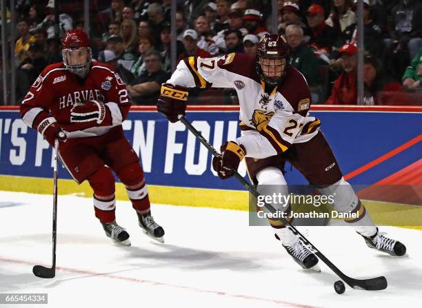 Riley Tufte of the Minnesota-Duluth Bulldogs controls the puck past Viktor Dombrovskiy of the Harvard Crimson during game one of the 2017 NCAA...