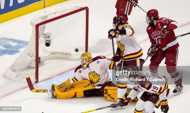 Hunter Miska of the Minnesota Duluth Bulldogs watches a puck shot by Tyler Moy of the Harvard Crimson , enter the net for a goal during game one of...