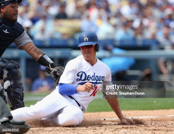 Kike Hernandez of the Los Angeles Dodgers beats the tag of catcher Hector Sanchez of the San Diego Padres as he scores to finish a double steal in...