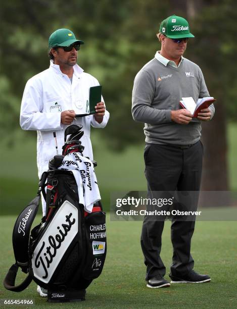 Caddie Brett Waldman, left, and golfer Charley Hoffman, right, look over their yardage books along the 17th fairway during first-round action of the...