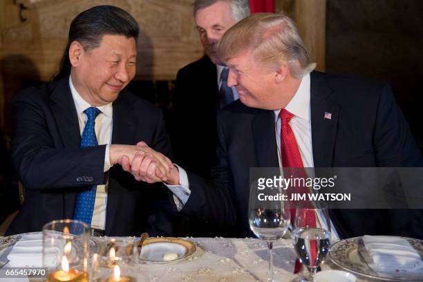 President Donald Trump and Chinese President Xi Jinping shake hands during dinner at the Mar-a-Lago estate in West Palm Beach, Florida, on April 6,...