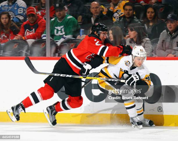 John Moore of the New Jersey Devils hits Josh Archibald of the Pittsburgh Penguins during the first period at the Prudential Center on April 6, 2017...