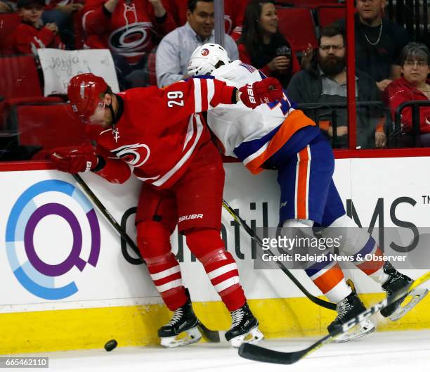 The Carolina Hurricanes' Bryan Bickell battles the New York Islanders' Scott Mayfield for the puck during the first period at PNC Arena in Raleigh,...