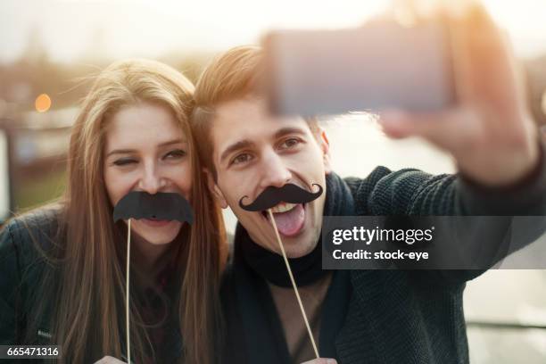 selfie mit gefälschten schnurrbärte - movember stock-fotos und bilder