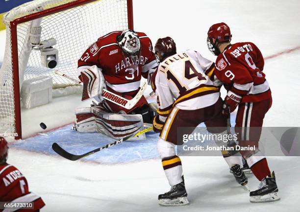 Alex Iafallo of the Minnesota-Duluth Bulldogs scores the game-winning goal with 26 seconds left in regulation against Merrick Madsen of the Harvard...