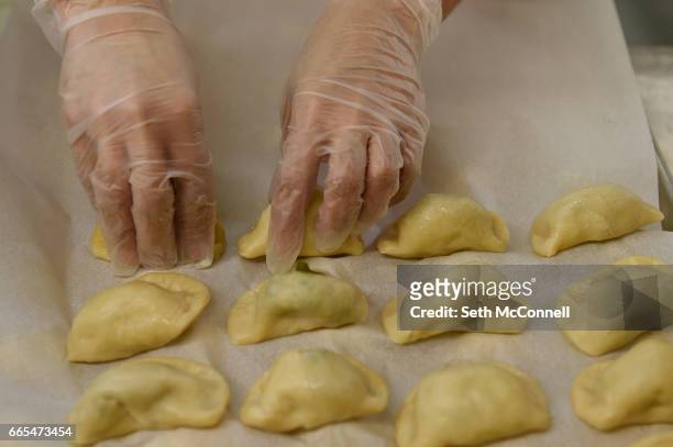 Maria Ledesma places chile relleno pierogis onto a pan to be packaged at a commercial kitchen on April 4 in Denver, Colorado. Baba & Pop's Handmade...