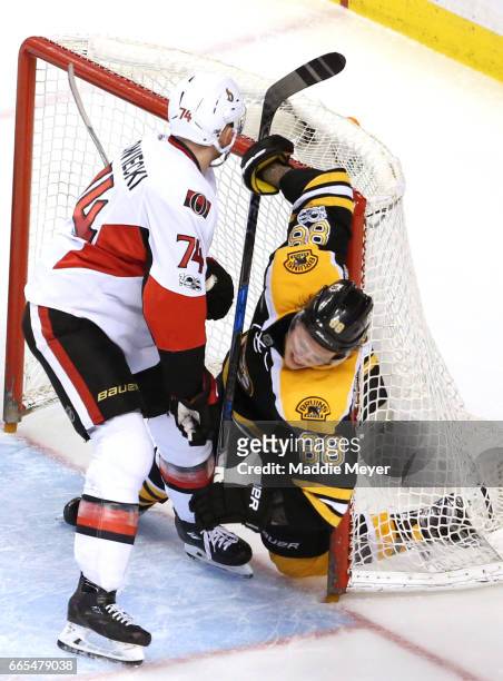 Mark Borowiecki of the Ottawa Senators checksDavid Pastrnak of the Boston Bruins into the goal during the third period at TD Garden on April 6, 2017...