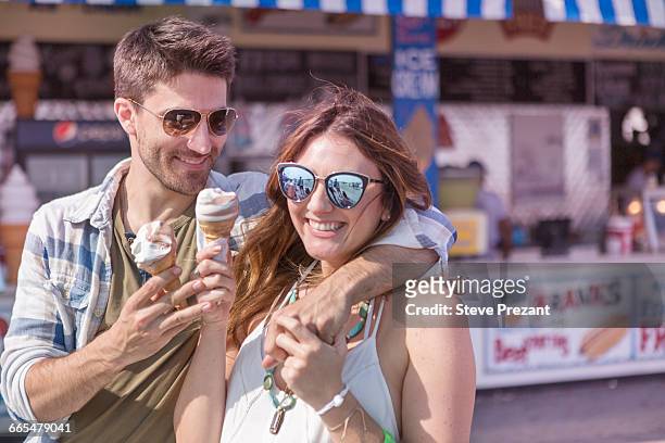 couple on promenade holding ice cream cones smiling, coney island, brooklyn, new york, usa - stand out escape stock-fotos und bilder