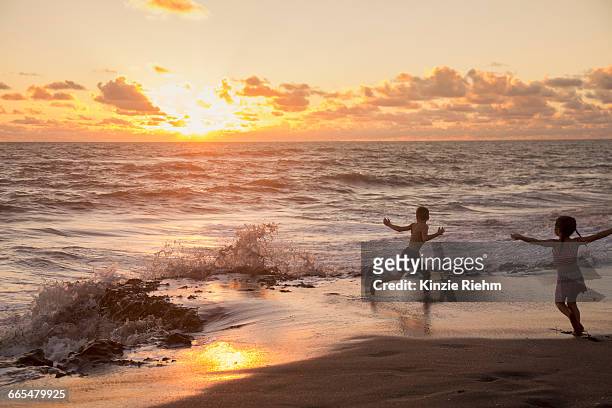 girl and brother running on beach at sunrise, blowing rocks preserve, jupiter island, florida, usa - beach florida family stockfoto's en -beelden