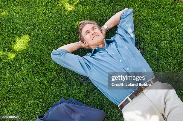 businessman relaxing on grass - lying on back stock pictures, royalty-free photos & images