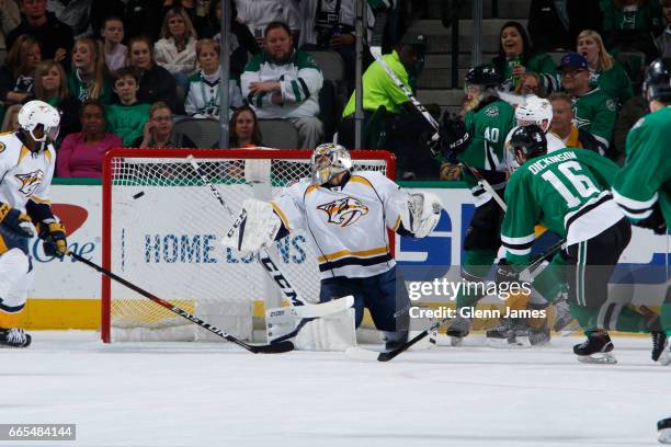 Juuse Saros of the Nashville Predators has a puck fired past him against Jason Dickinson of the Dallas Stars at the American Airlines Center on April...