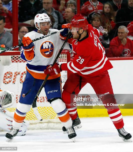 The Carolina Hurricanes' Bryan Bickell and the New York Islanders' Johnny Boychuk jostle for position in front of the net during the second period at...