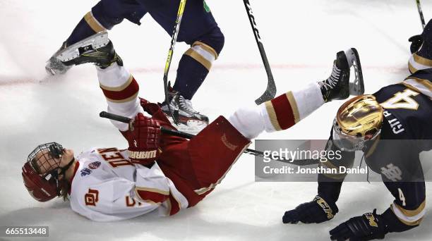 Henrik Borgstrom of the Denver Pioneers is knocked to the ice by Dennis Gilbert of the Notre Dame Fighting Irish during game two of the 2017 NCAA...