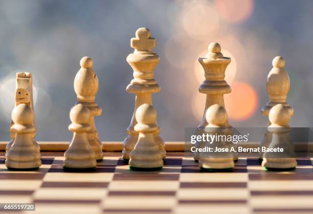 chessboard on a table illuminated by the light of the sun outdoors - liderazgo stock-fotos und bilder